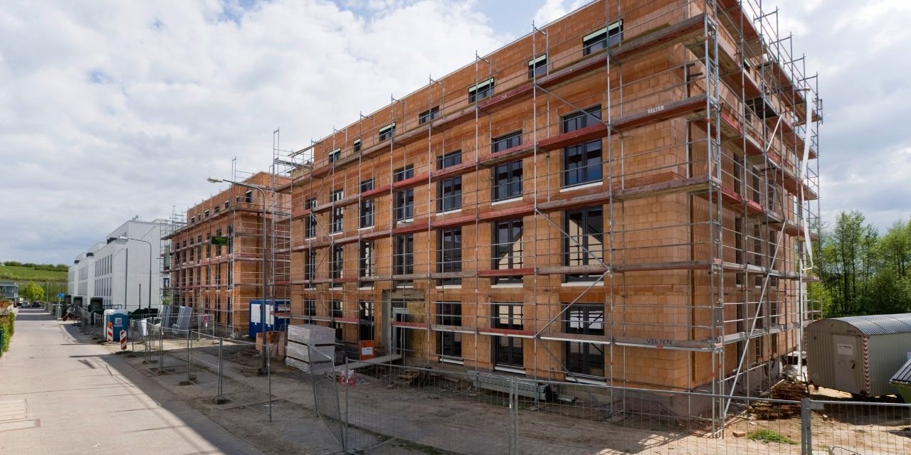 Construction site photo with railing surrounded by fences / Poroton S10-42,5-P